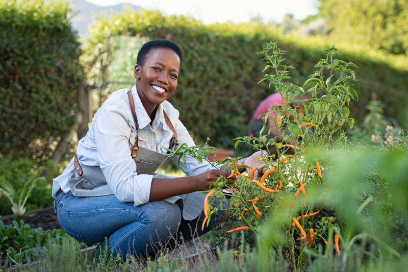 Woman smiling while caring for a plant