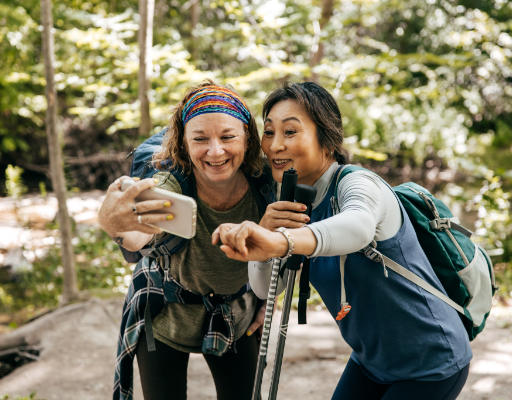Two women taking a selfie while hiking in a forest